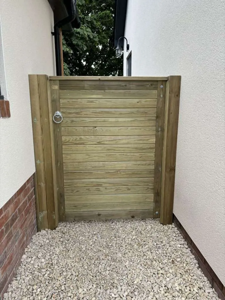 Timber gate beside a garden wall