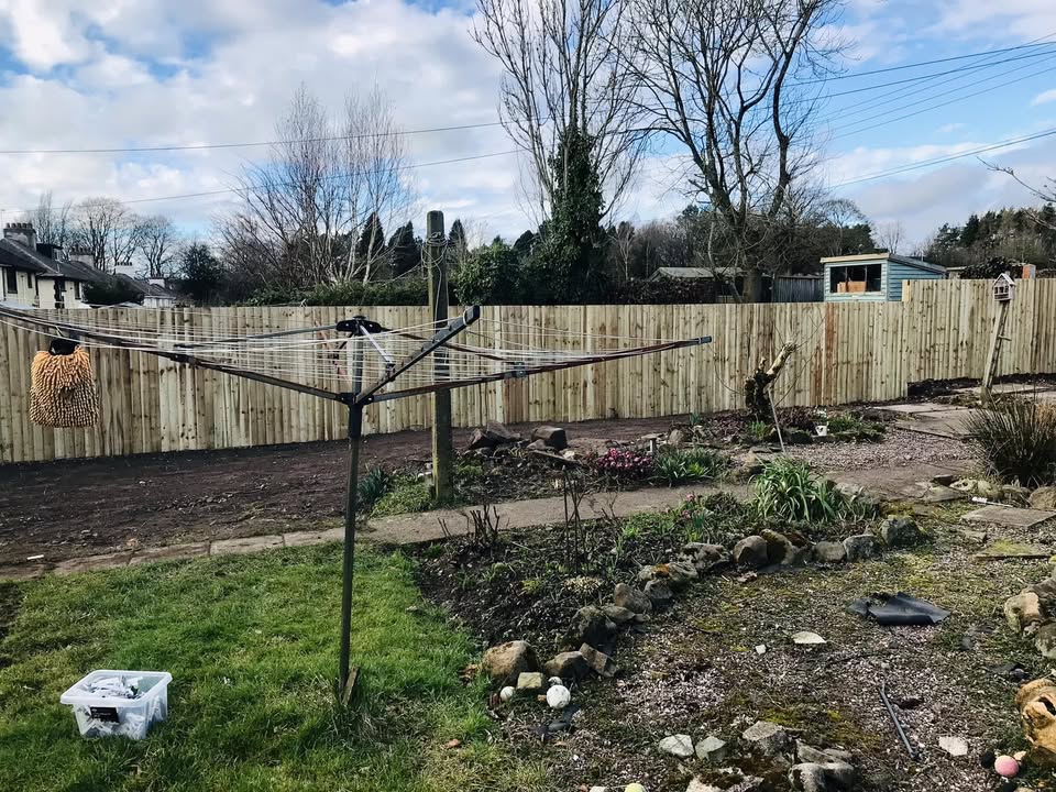 Cheddleton garden after hedge removal, with a new timber boundary, lawn, flower beds and a rotary clothesline