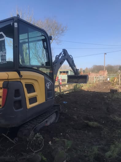 Cheddleton hedge-removal project with a yellow mini excavator working on cleared ground