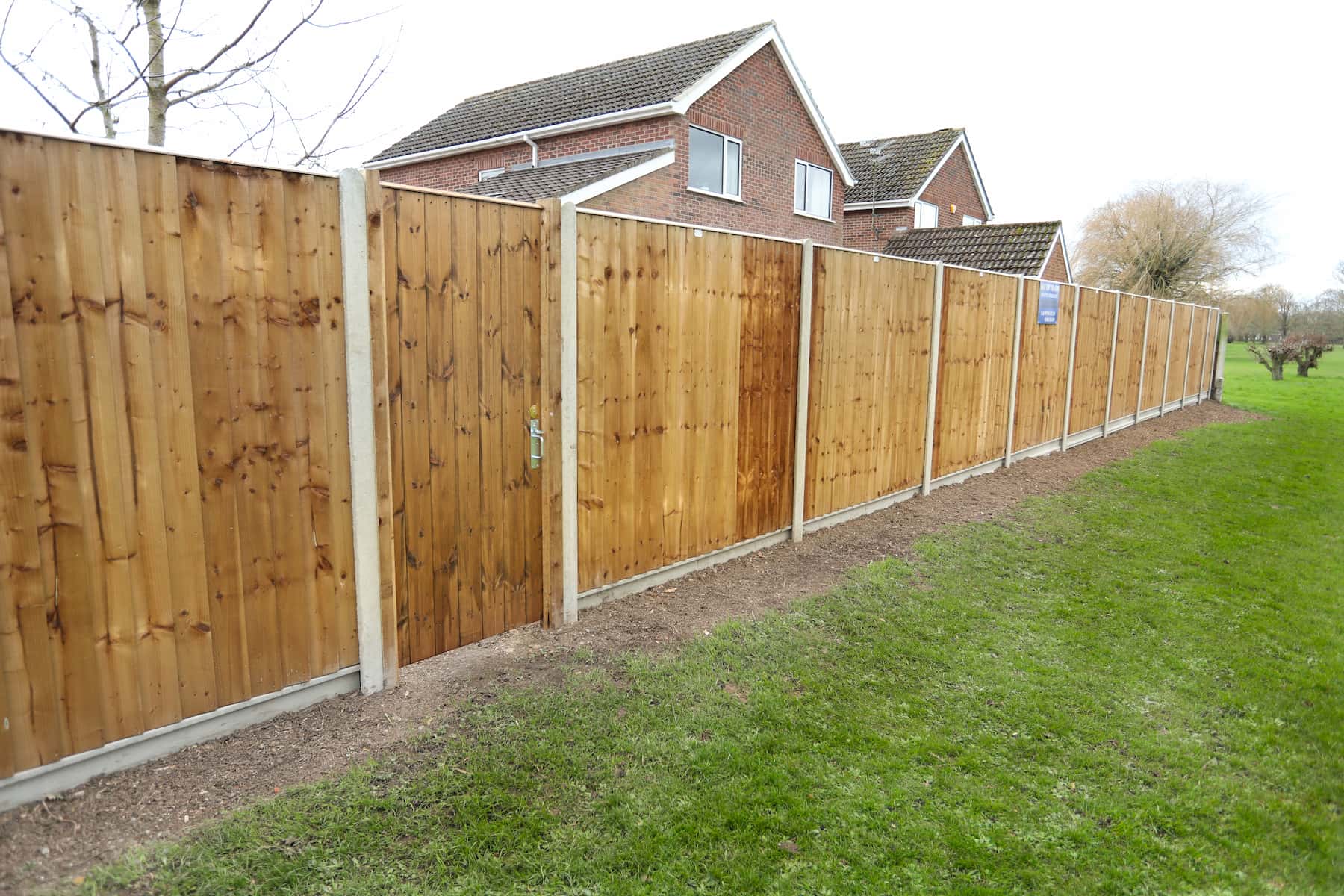 Timber fence panels and posts beside a garden